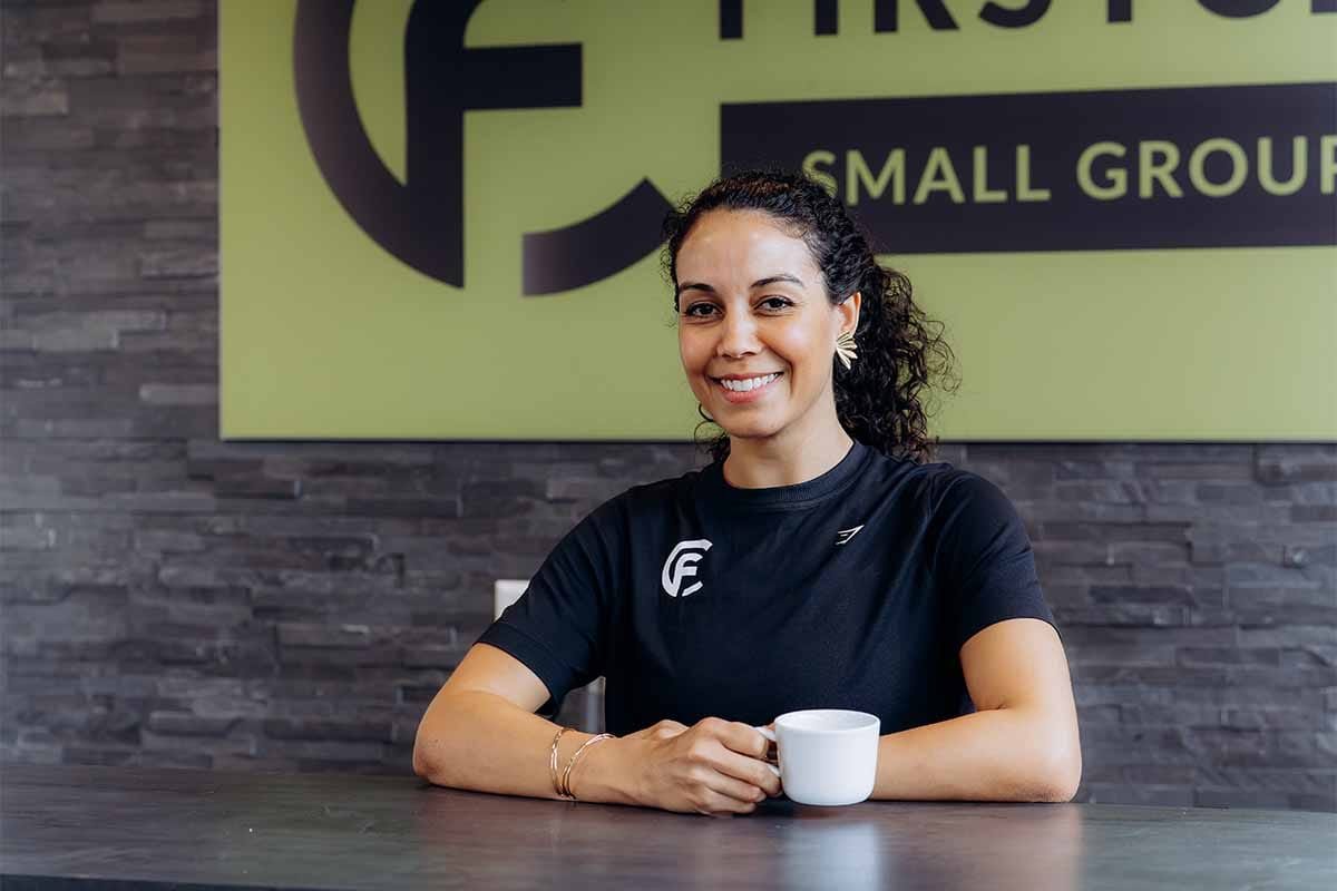 Personal trainer in Delft helpt klant met krachttraining in de studio van First Class Fitness.